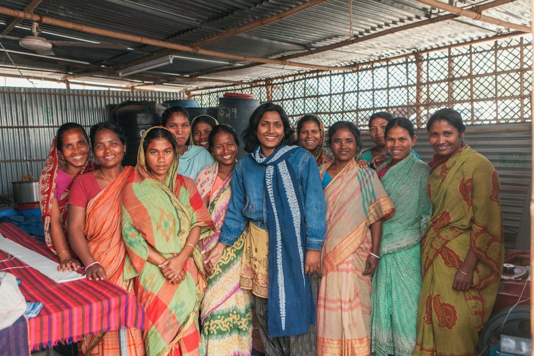 A group of women in colorful saris smile together