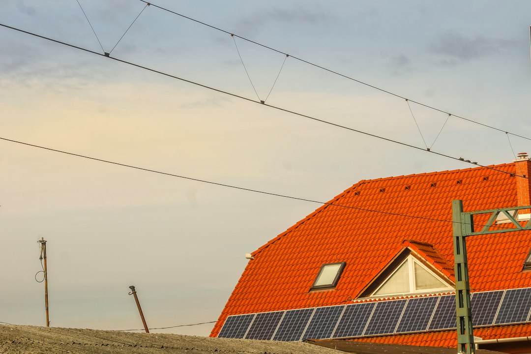 Orange roof with solar panels and overhead wires