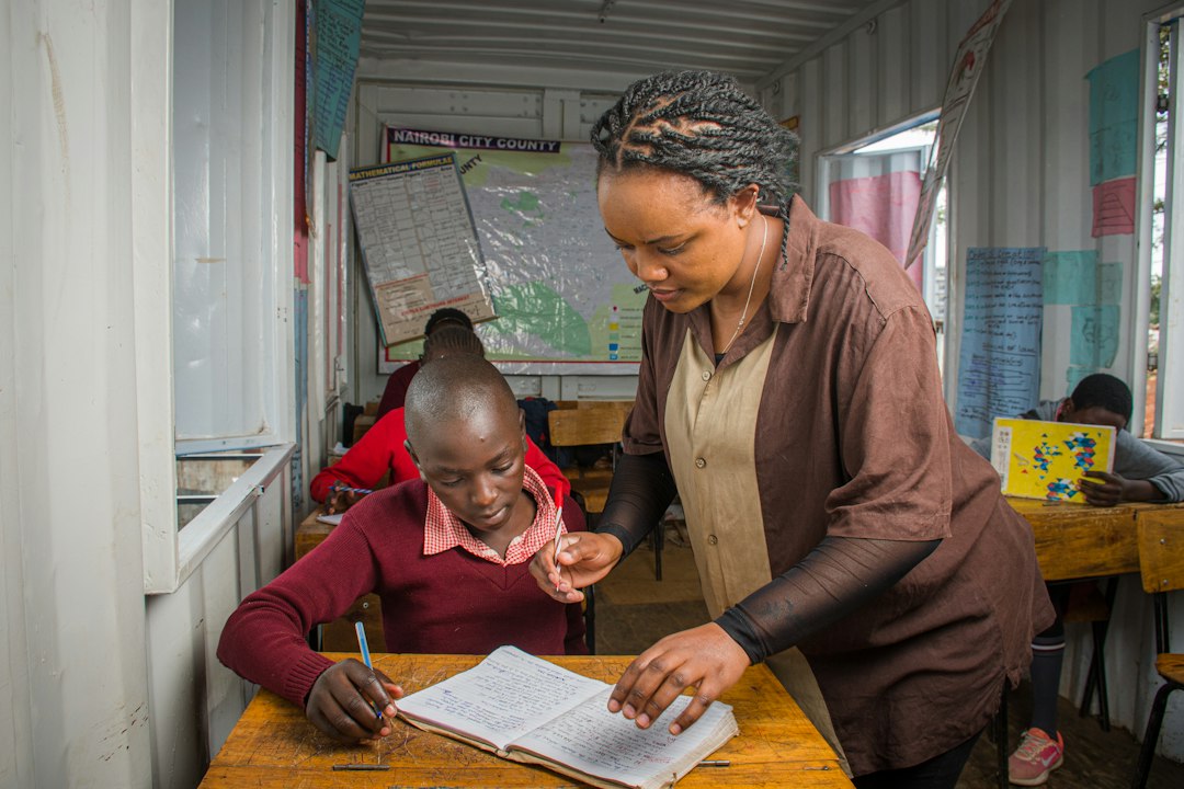 A teacher assists a student in a classroom