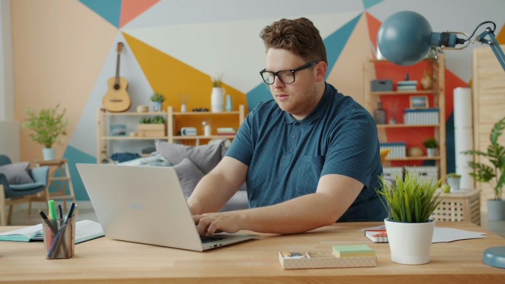 Man working on laptop at a colorful desk